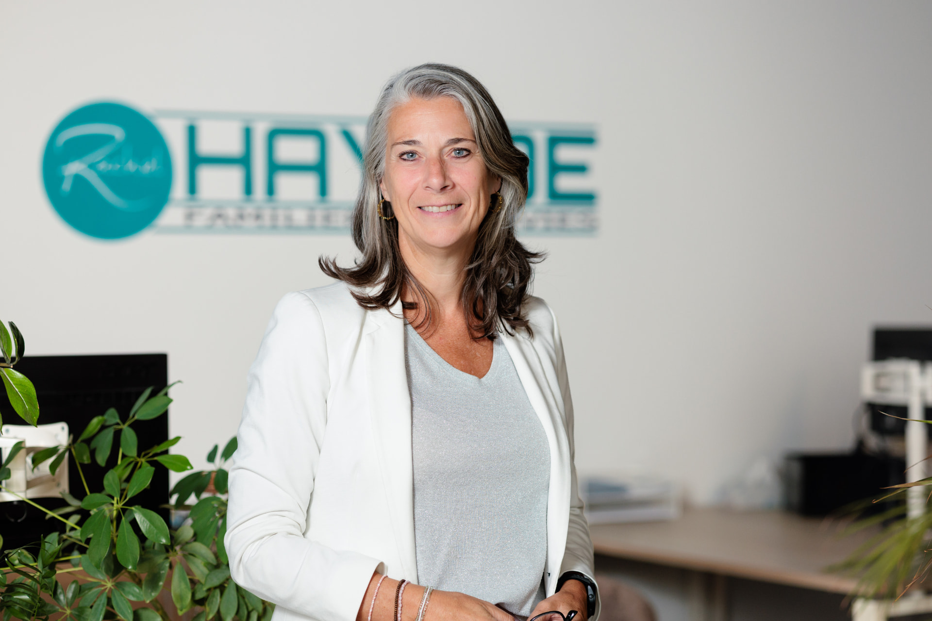 Rachel Hayhoe voor het logo van Hayhoe Familierechtadvies op kantoor